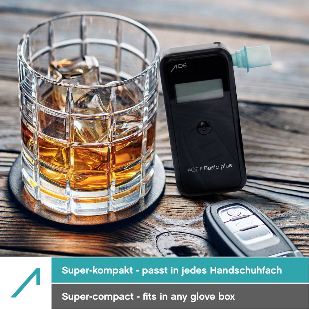 'Een gevuld whiskyglas met een alcoholtester en een autosleutel op een tafel. Tekst: Super-compact - past in elk dashboardkastje.'