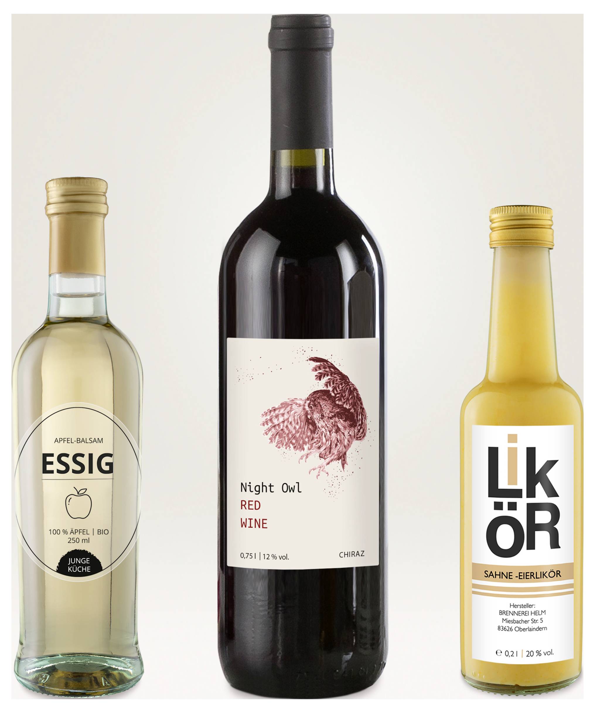 Drie flessen: appelazijn links, rode wijn 'Night Owl' in het midden en roomlikeur rechts, elk met etiket tegen een lichte achtergrond.