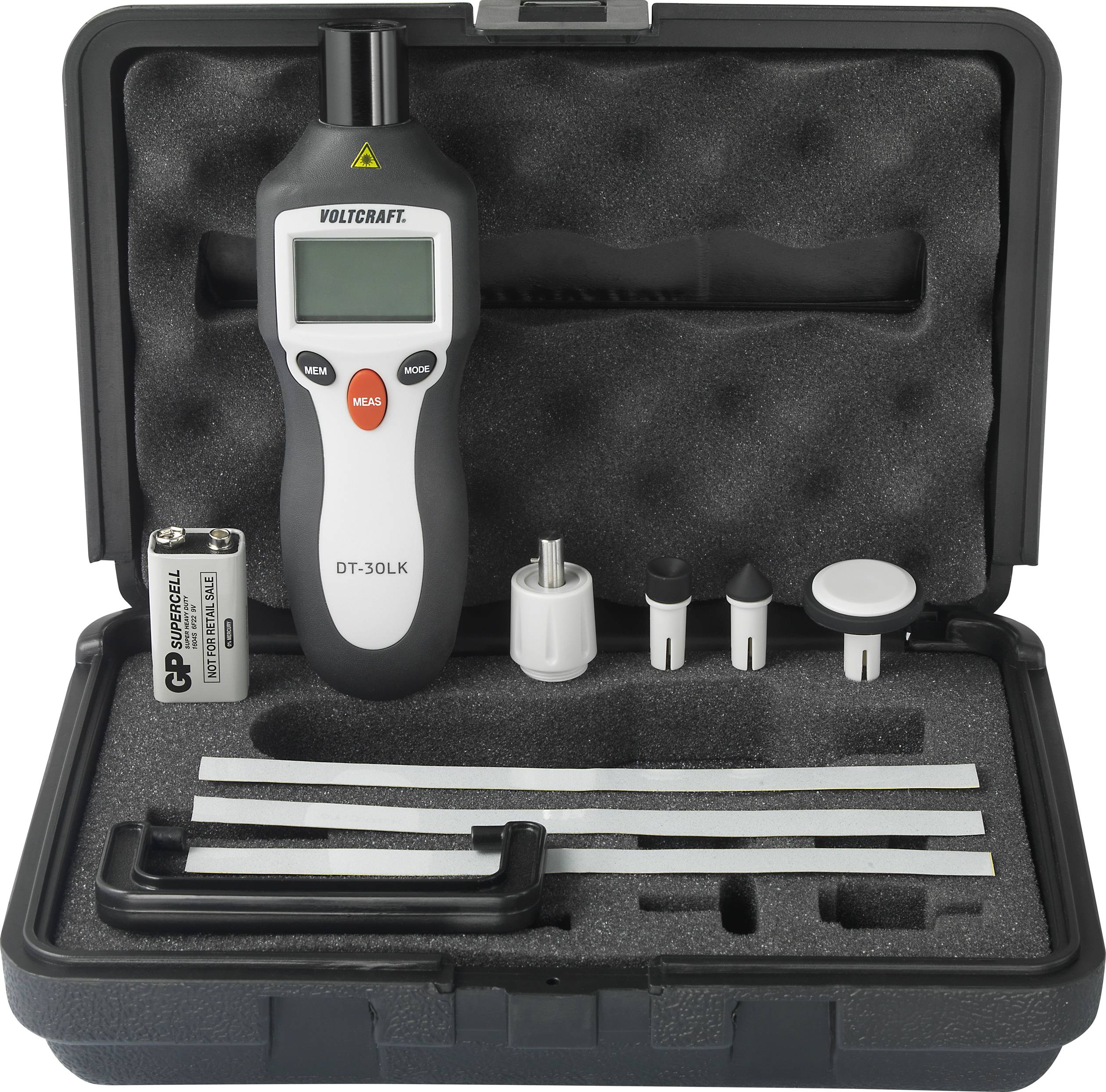 Een tachometer-set met digitaal handapparaat, batterij en toebehoren in een zwarte koffer. Het display toont actuele meetwaarden.