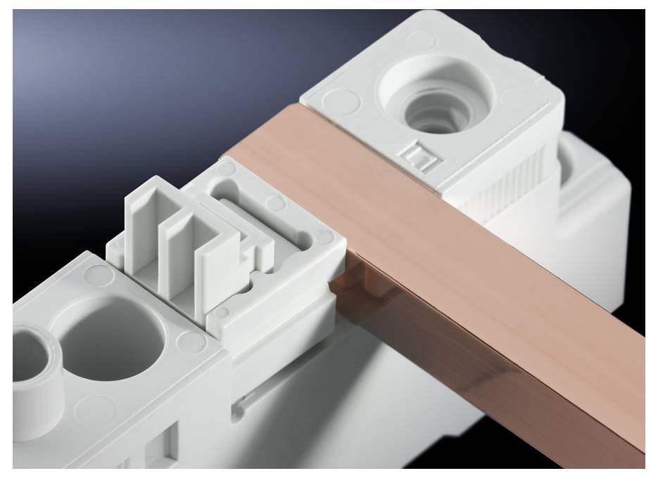 Witte elektrische schakeelcomponent met koperen geleiderstaaf. Hoofdonderdeel in een elektrische installatie voor stroomverdeling.