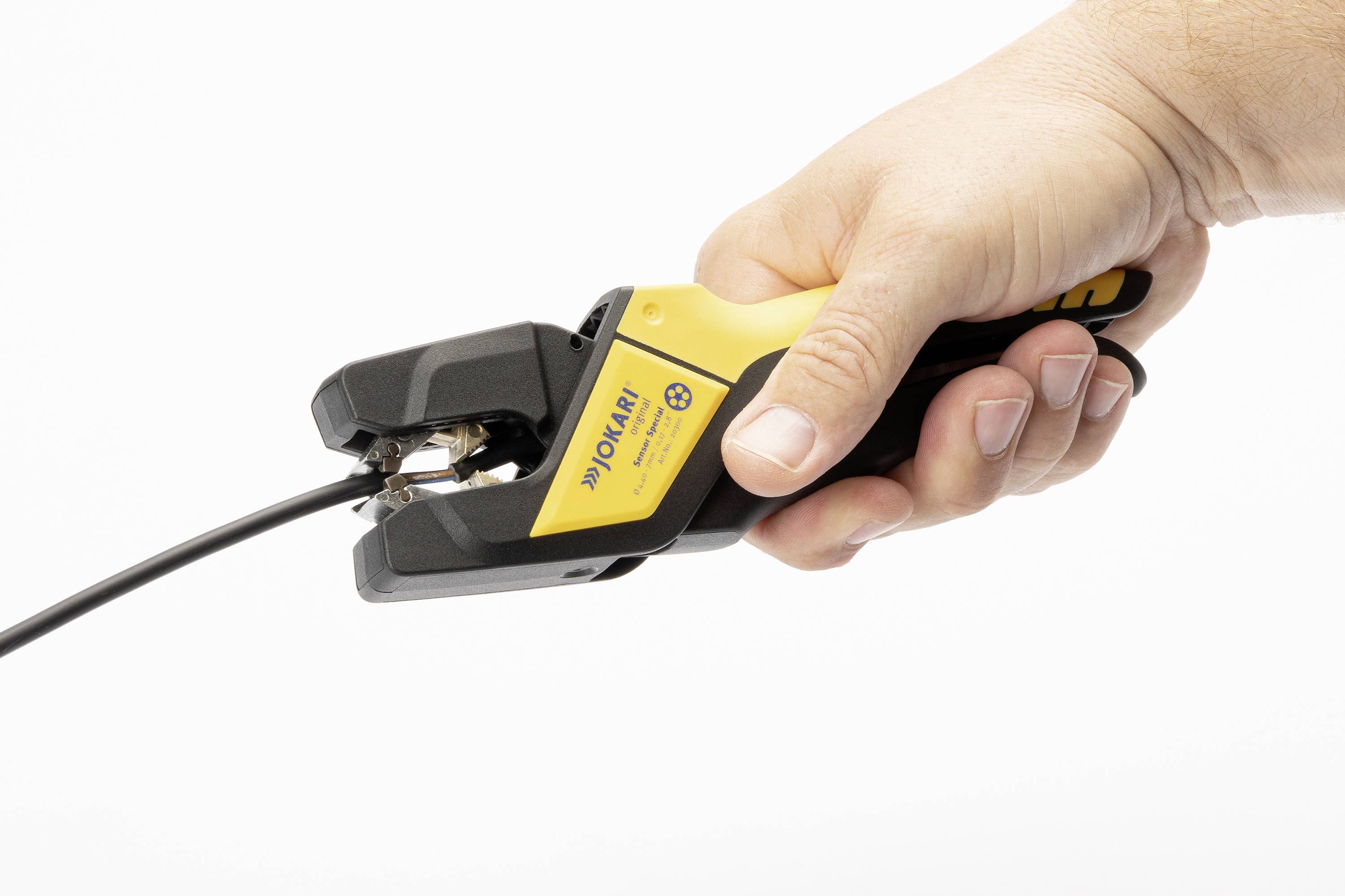 Een hand houdt een gele en zwarte kabelkniptang vast om het uiteinde van een zwart kabel door te knippen.