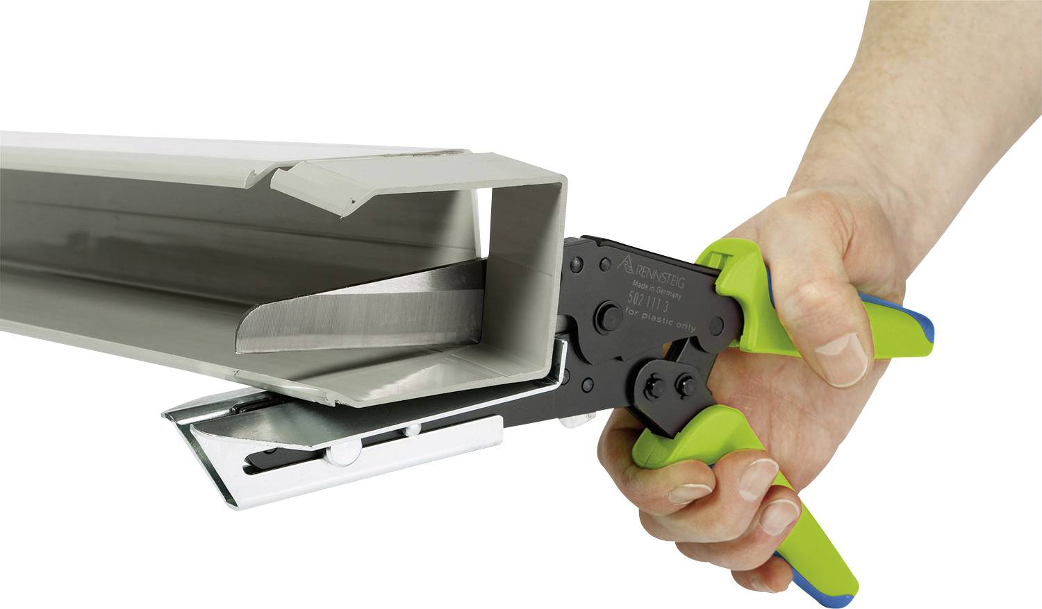 Een hand houdt een groene en zwarte nijptang vast en bewerkt een grijs metalen profiel, waarschijnlijk ten behoeve van installatie of montage.