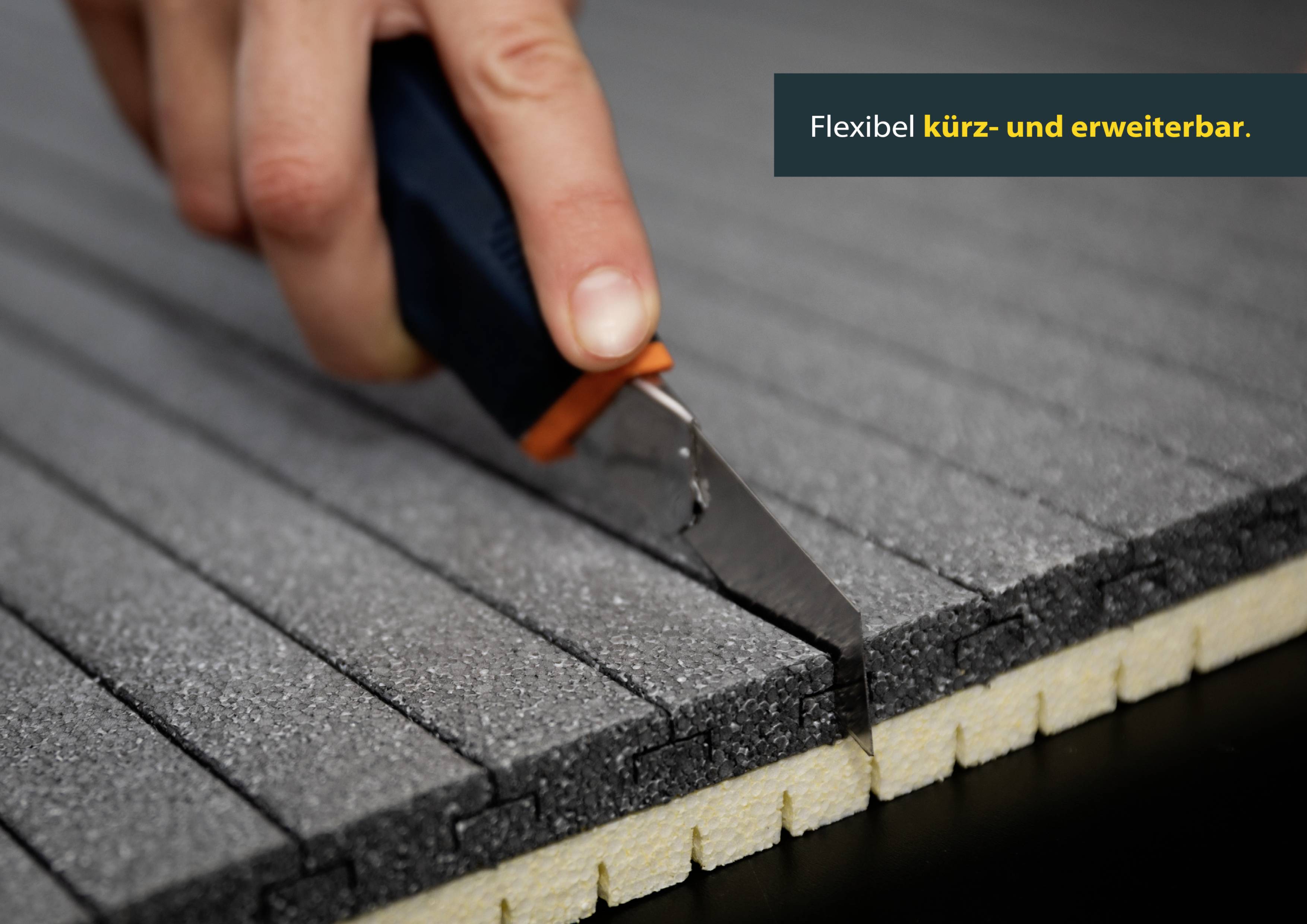 Hand gebruikt mes om grijze isolatie in precies gesneden stroken te knippen. Tekst zegt: 'Flexibel in te korten en uit te breiden.'