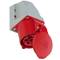 Een rode industriële stopcontact met beschermkap, gemonteerd op een grijze wandsteun. Geschikt voor krachtige elektrische aansluitingen.