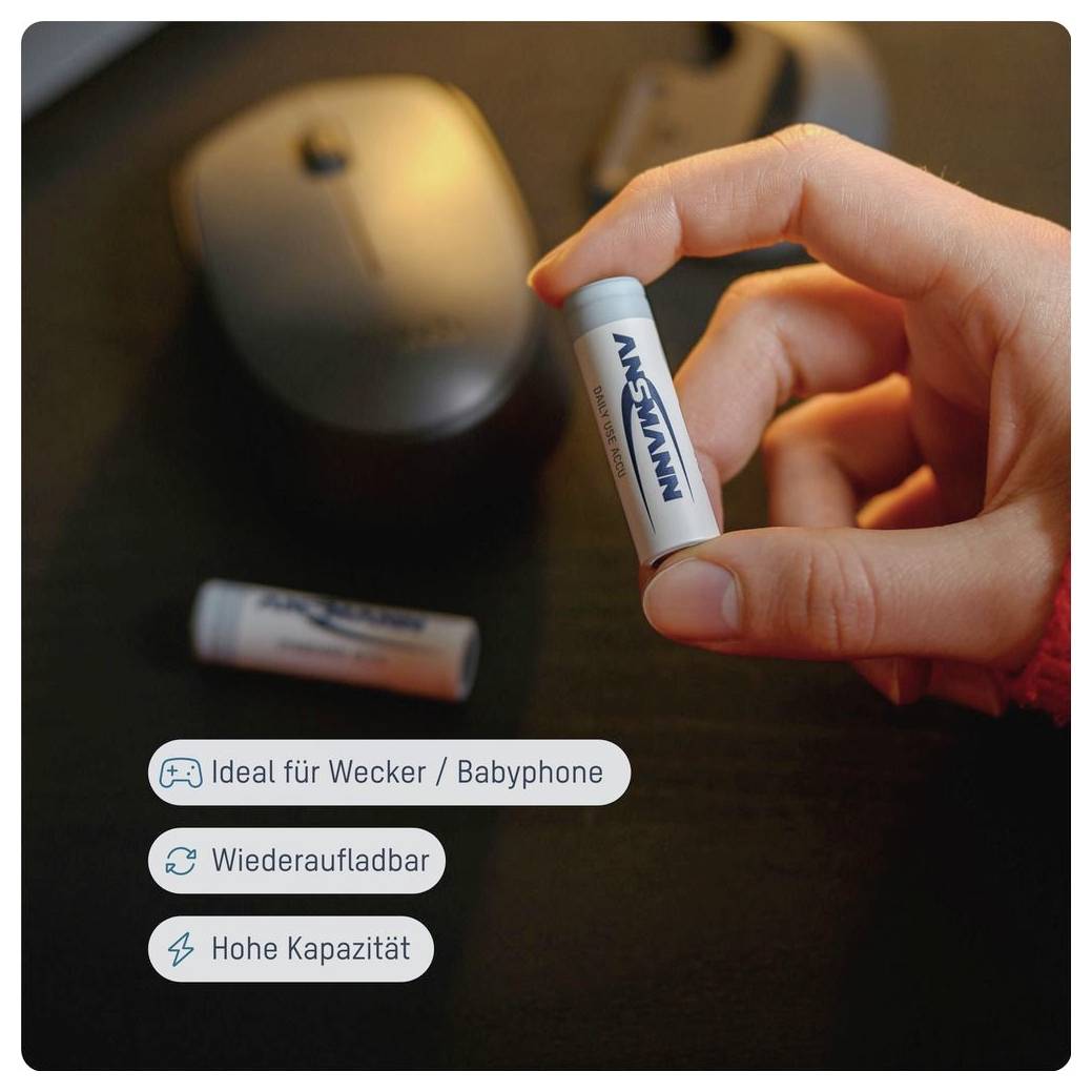 Hand houdt een NAVISAN oplaadbare batterij vast in de buurt van een computermuis, met Duitse labels die 'Ideaal voor wekkers / babytelefoons', 'Oplaadbaar' en 'Hoge capaciteit' lezen.