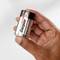 Een hand houdt een AA-batterij van het merk Energizer Max.