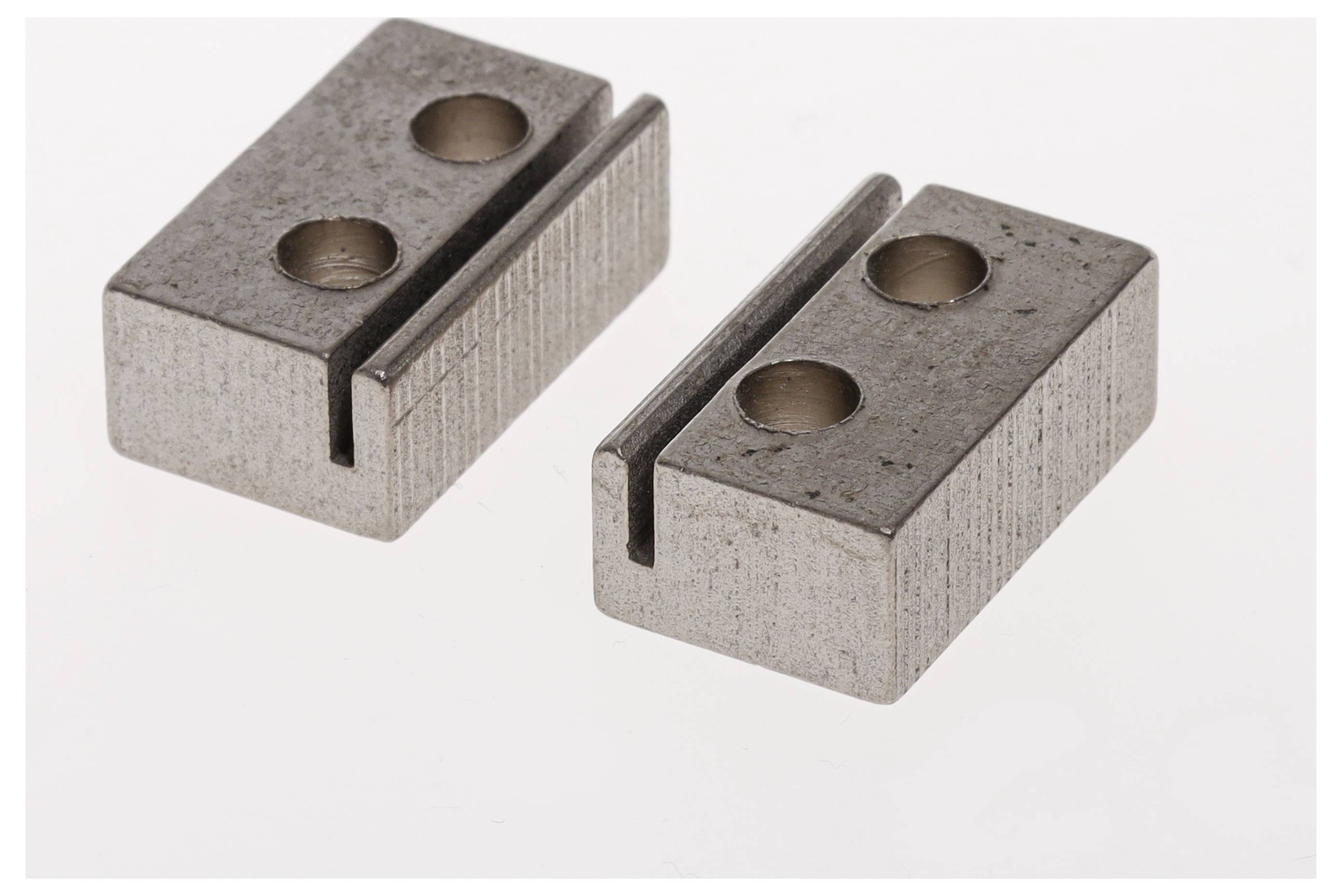 Twee grijze metalen blokken met inkepingen en gaten op een witte achtergrond.