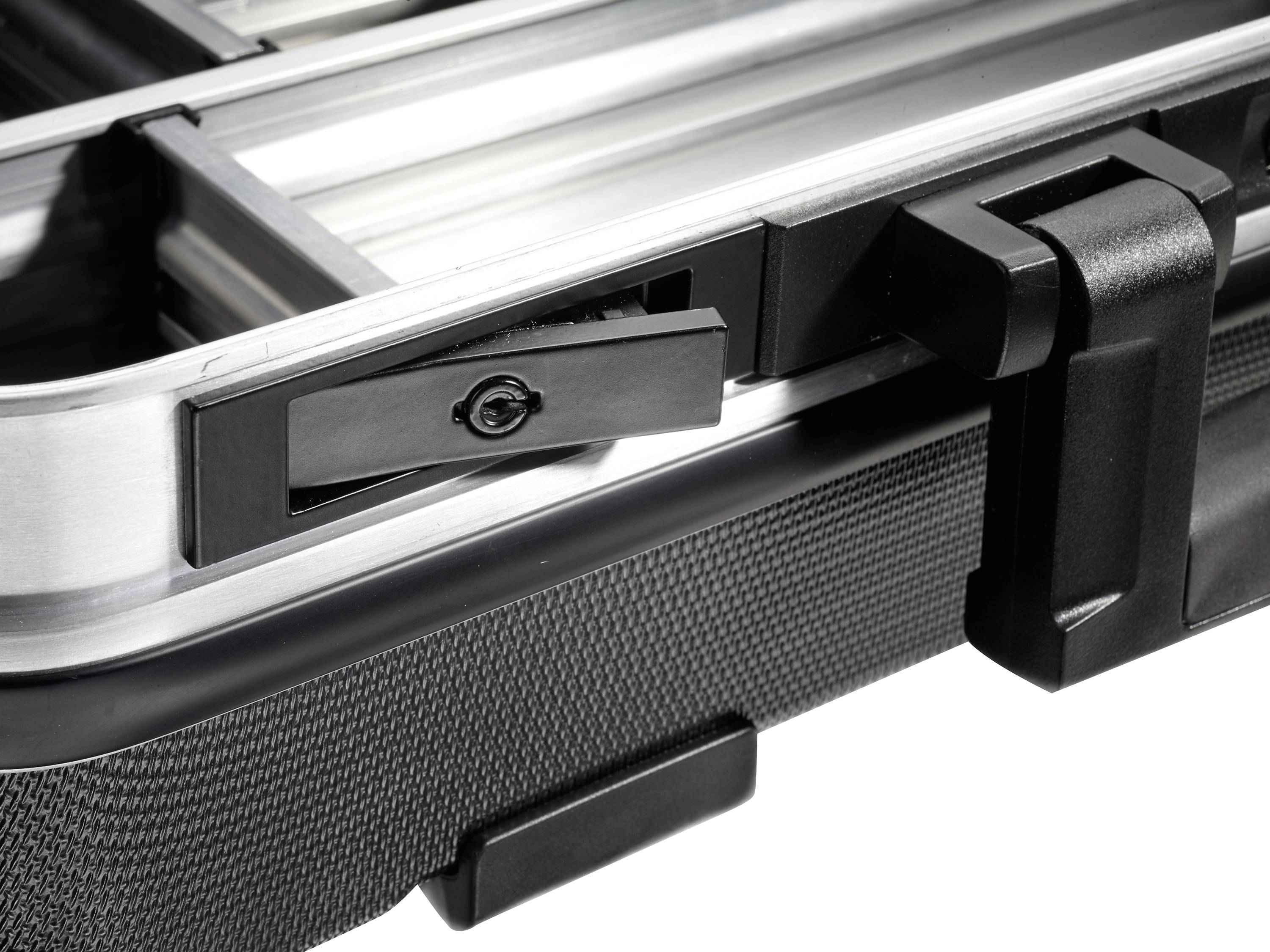 Close-up van een open, lege gereedschapskoffer met een zwarte sluiting en metalen frame, zonder zichtbare inhoud.