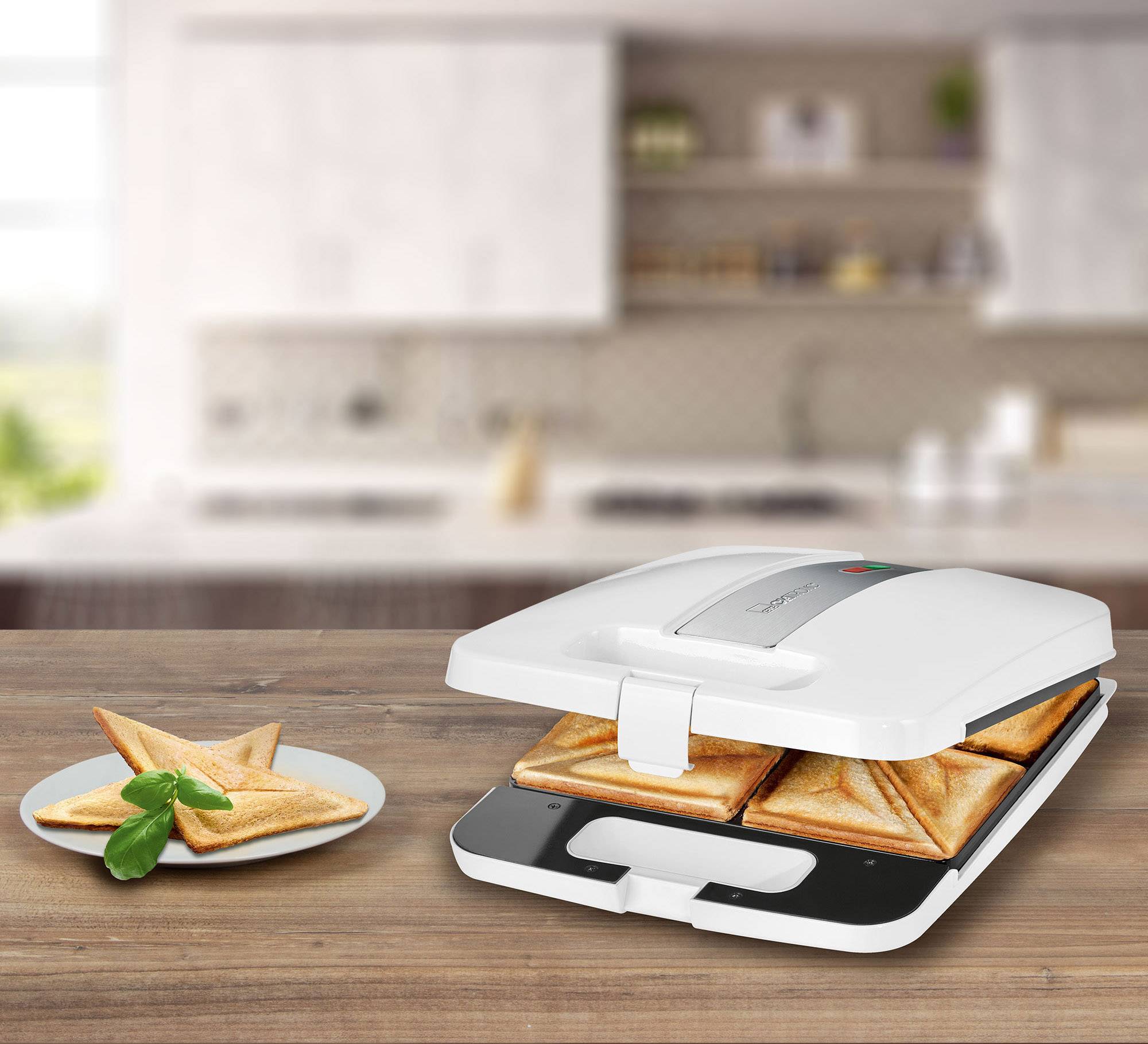 Een tosti-ijzer op een houten plank met twee geroosterde tosti's in het apparaat en een bord met twee broodjes links vooraan.