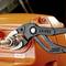 'KNIPEX Cobra'-tang houdt een metalen adapter vast aan een oranje machine met een 'R2.CP' sticker.