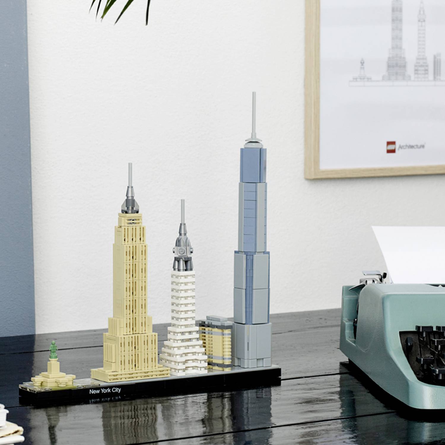 'Miniatuurmodellen van wolkenkrabbers, waaronder het Empire State Building en het Chrysler Building. Een retro-typemachine staat ernaast.'