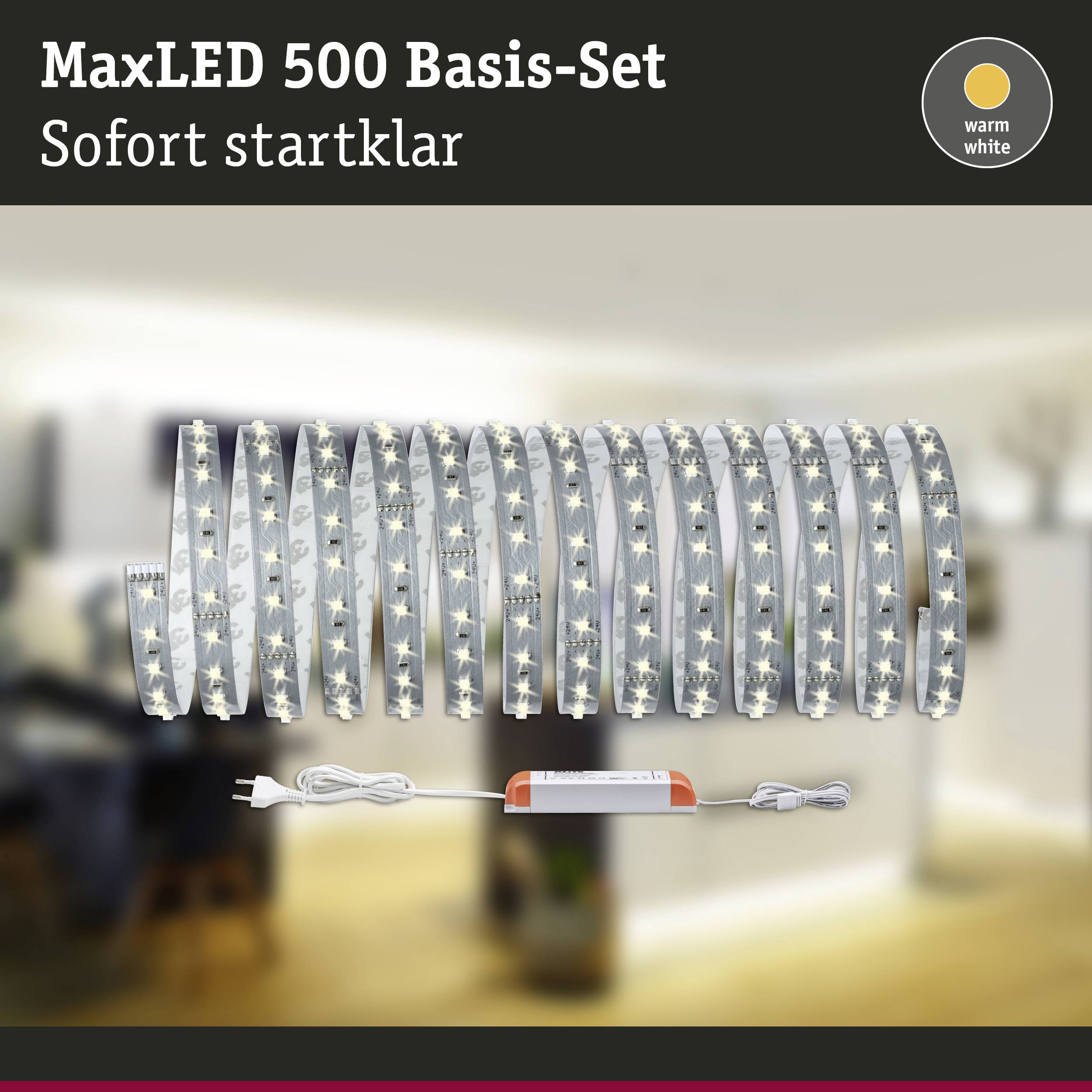 'MaxLED 500 Basis-Set' ledstrip op rol, oplichtend in warmwit. Op de achtergrond wazig een woonruimte. Tekst: "Direct klaar voor gebruik".