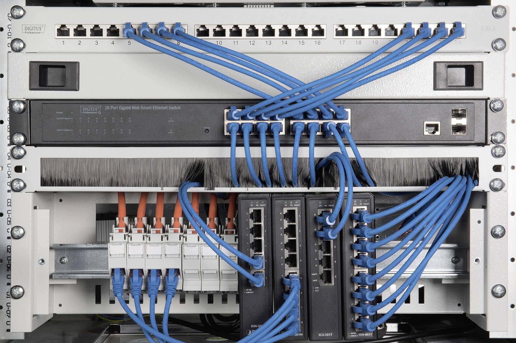 Een netwerkrek met meerdere switches en blauwe Ethernet-kabels die in poorten zijn aangesloten, toont een georganiseerde bekabeling.
