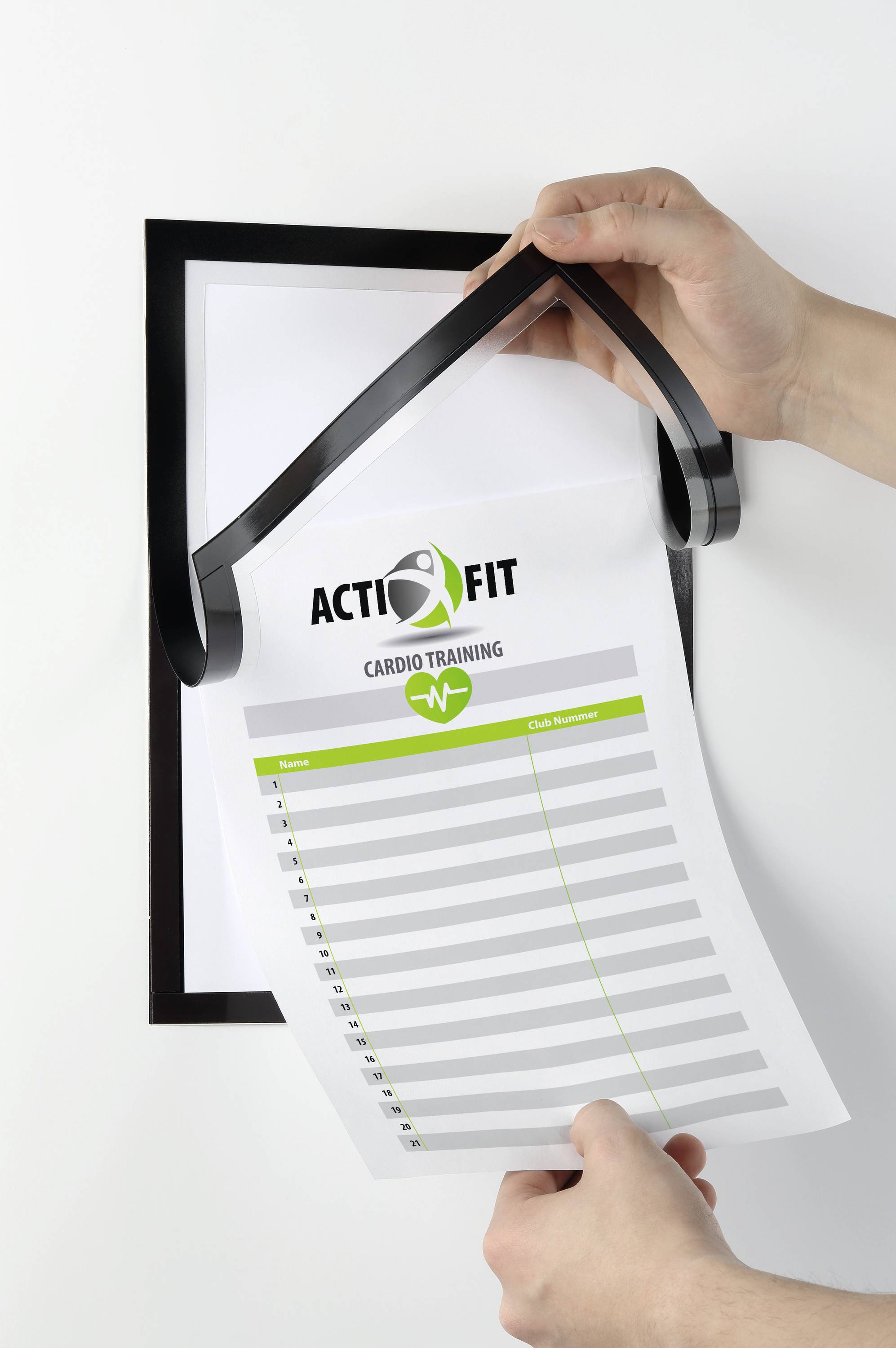 Een hand bladert door een ingelijste tabel met de titel 'ACTIFIT Cardio Training'. Eronder een lijst met onbeschreven regels.