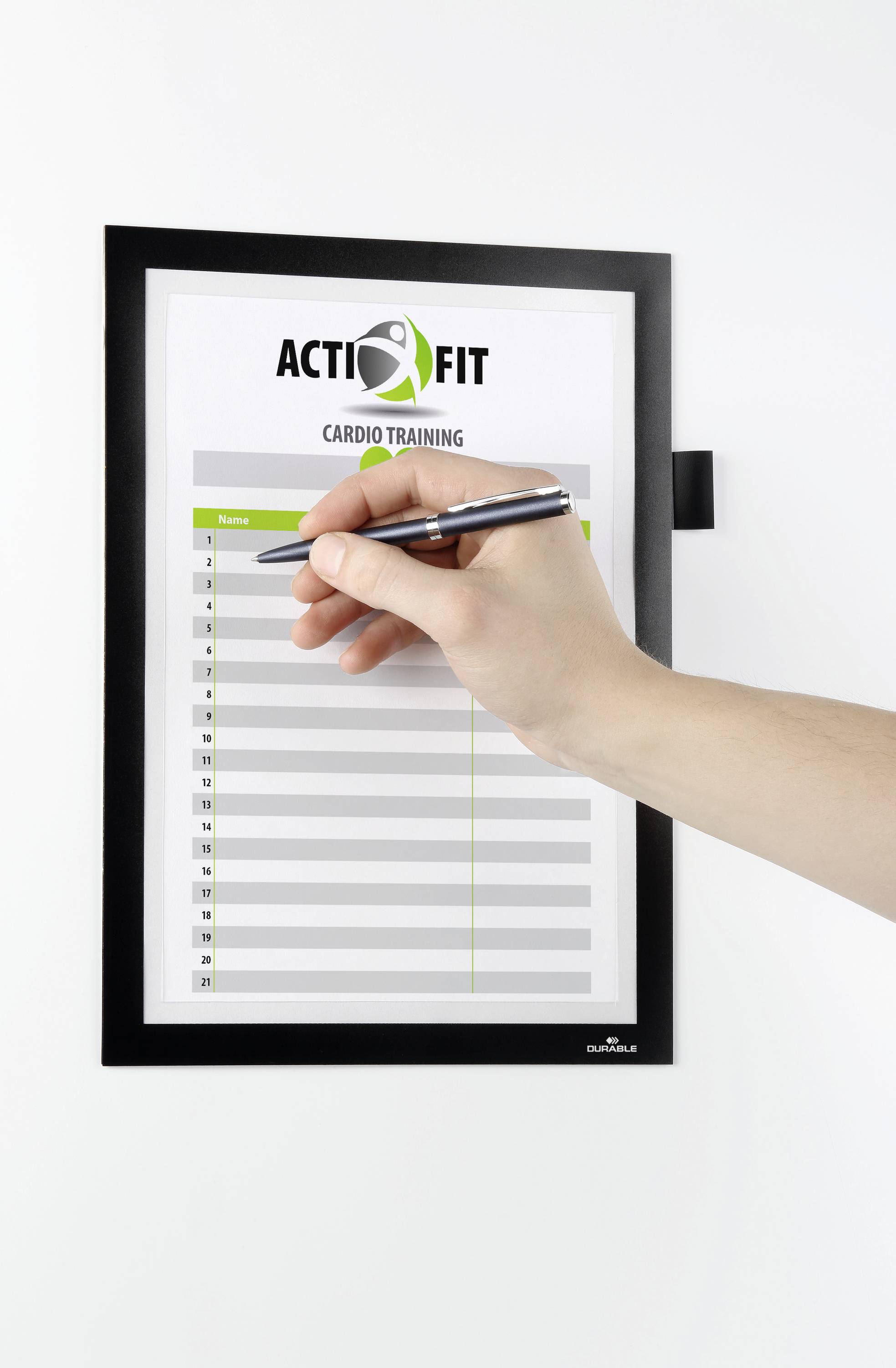 Een hand houdt een pen vast en schrijft op een formulier met de kop 'Action Fit Cardio Training'. Het formulier heeft lege regels.