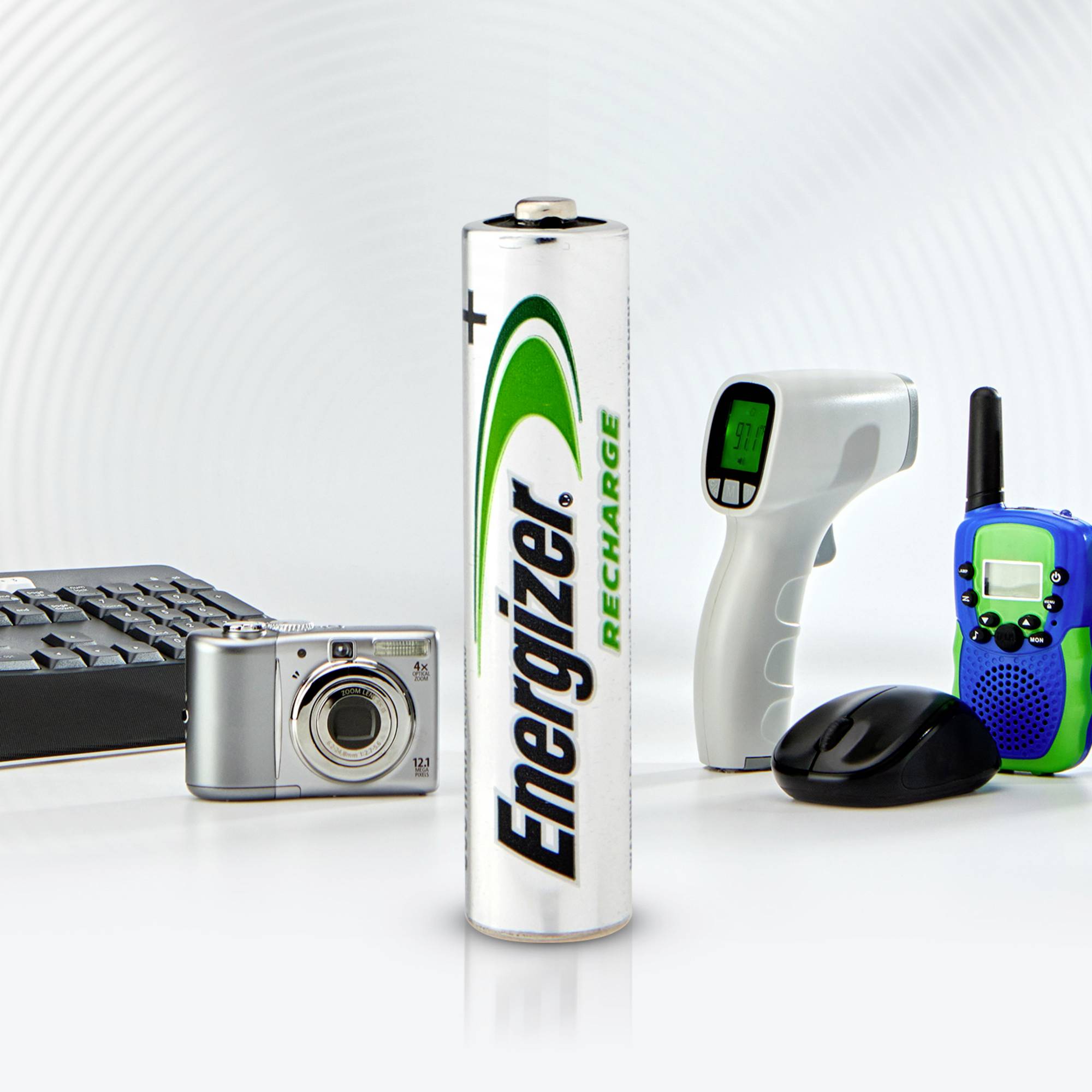 Een "Energizer Recharge"-batterij staat centraal, naast een camera, toetsenbord, infrarood-thermometer en een walkietalkie. Het thema is herlaadbaarheid.