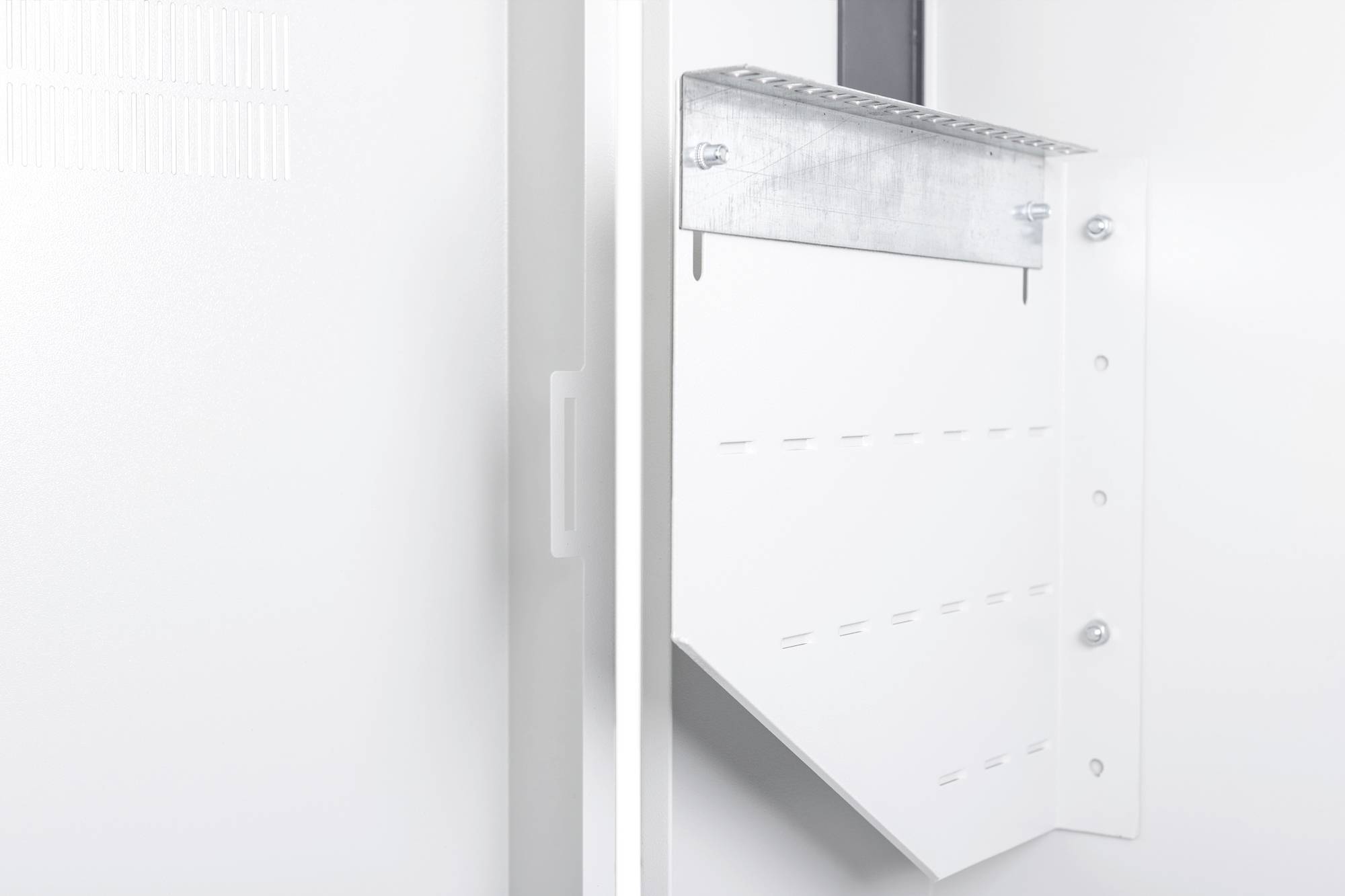 Een witte metalen steun aan een muur, die dient ter ondersteuning van apparaten of installaties, bevestigd met schroeven.
