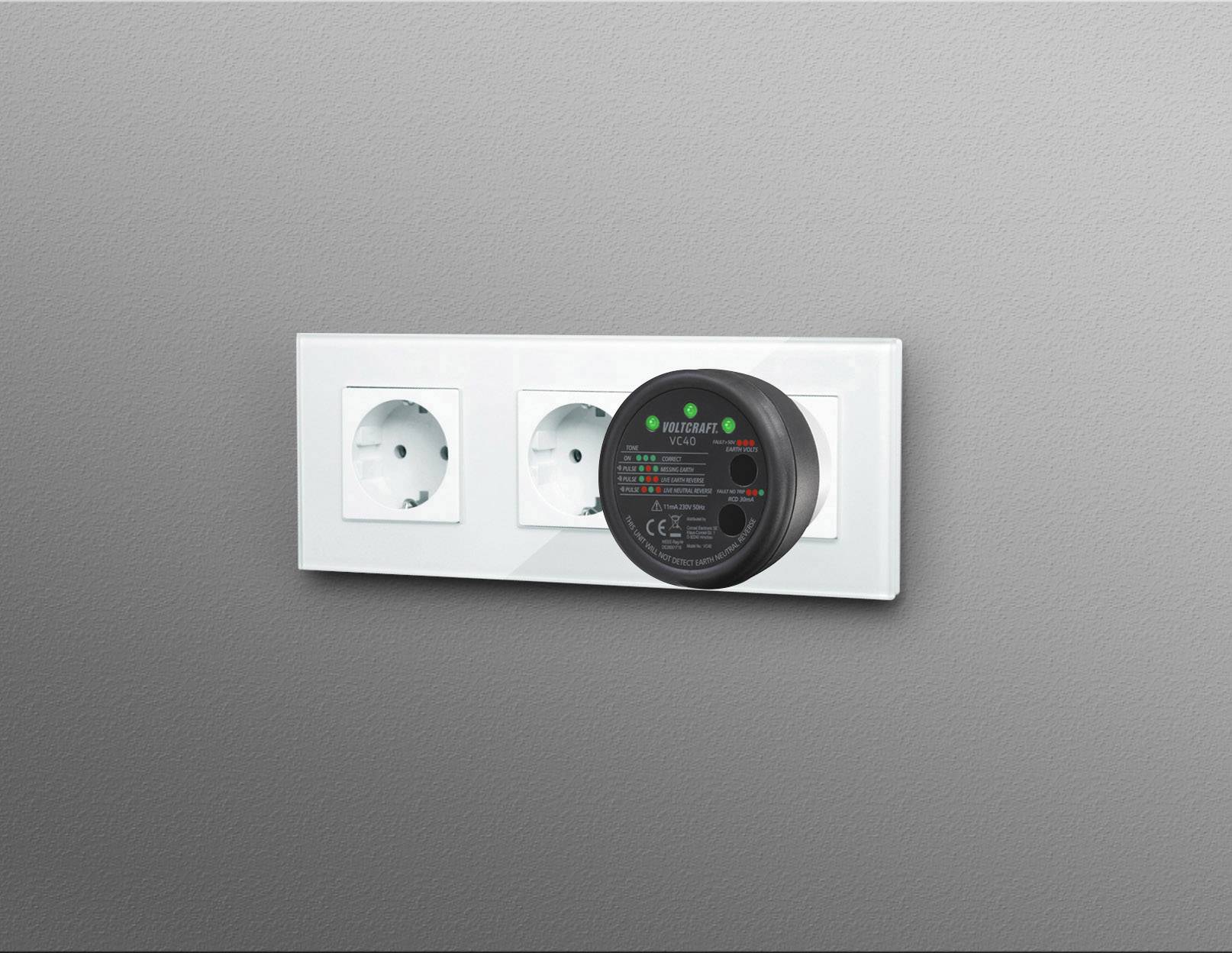 Drie witte stopcontacten aan een grijze muur met een digitale meter die is aangesloten in het rechter stopcontact.