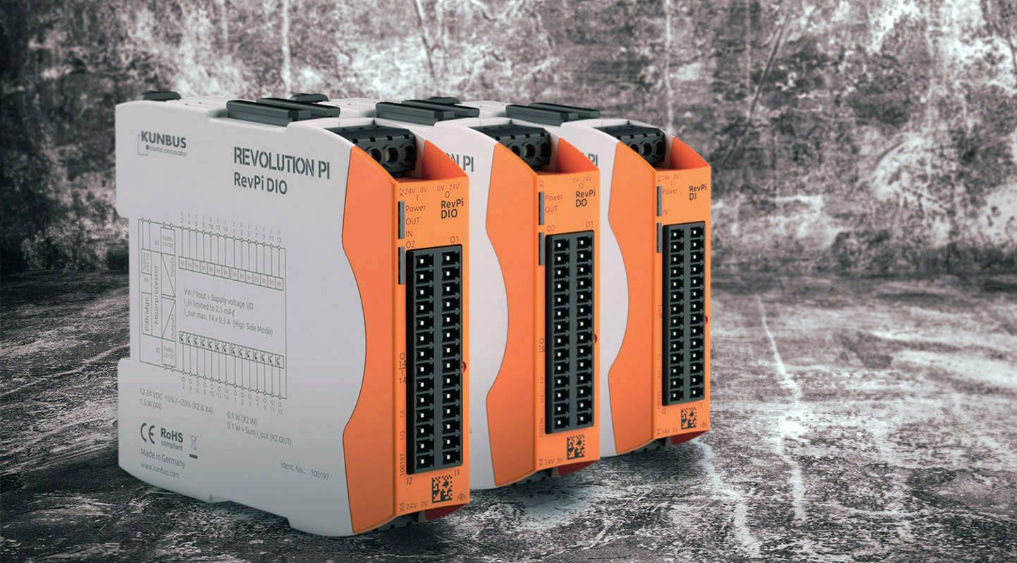 Vier oranje-witte industriële modules van KUNBUS met het opschrift 'Revolution PI RevPi DIO', op een gestructureerde grijze ondergrond.