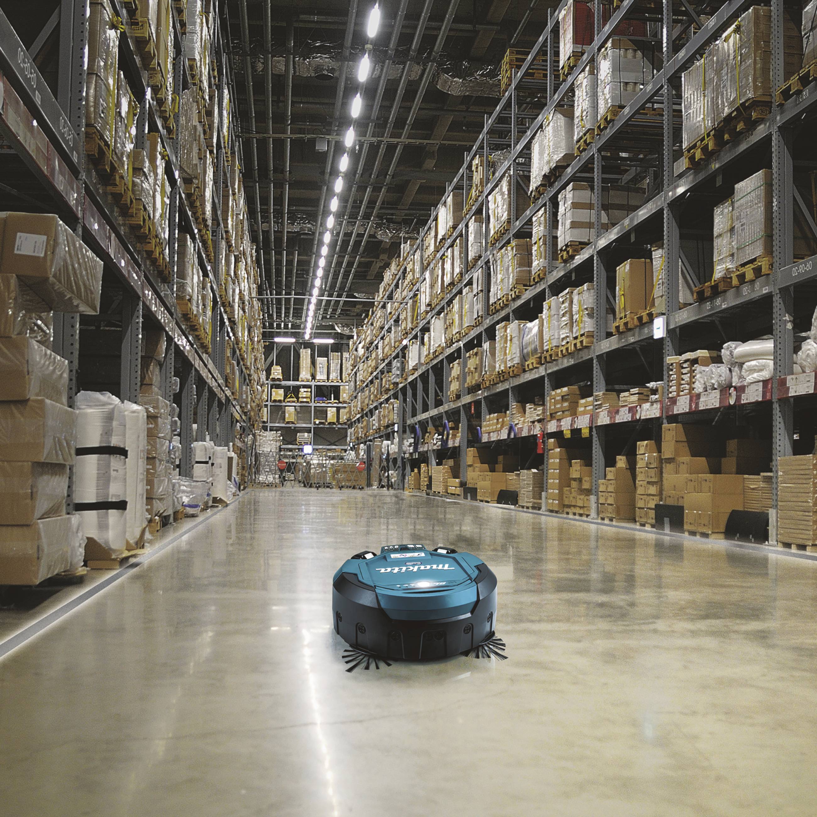 Robot beweegt zich autonoom door een groot magazijn vol stellingen en pakketten. De vloer is schoon en goed verlicht.