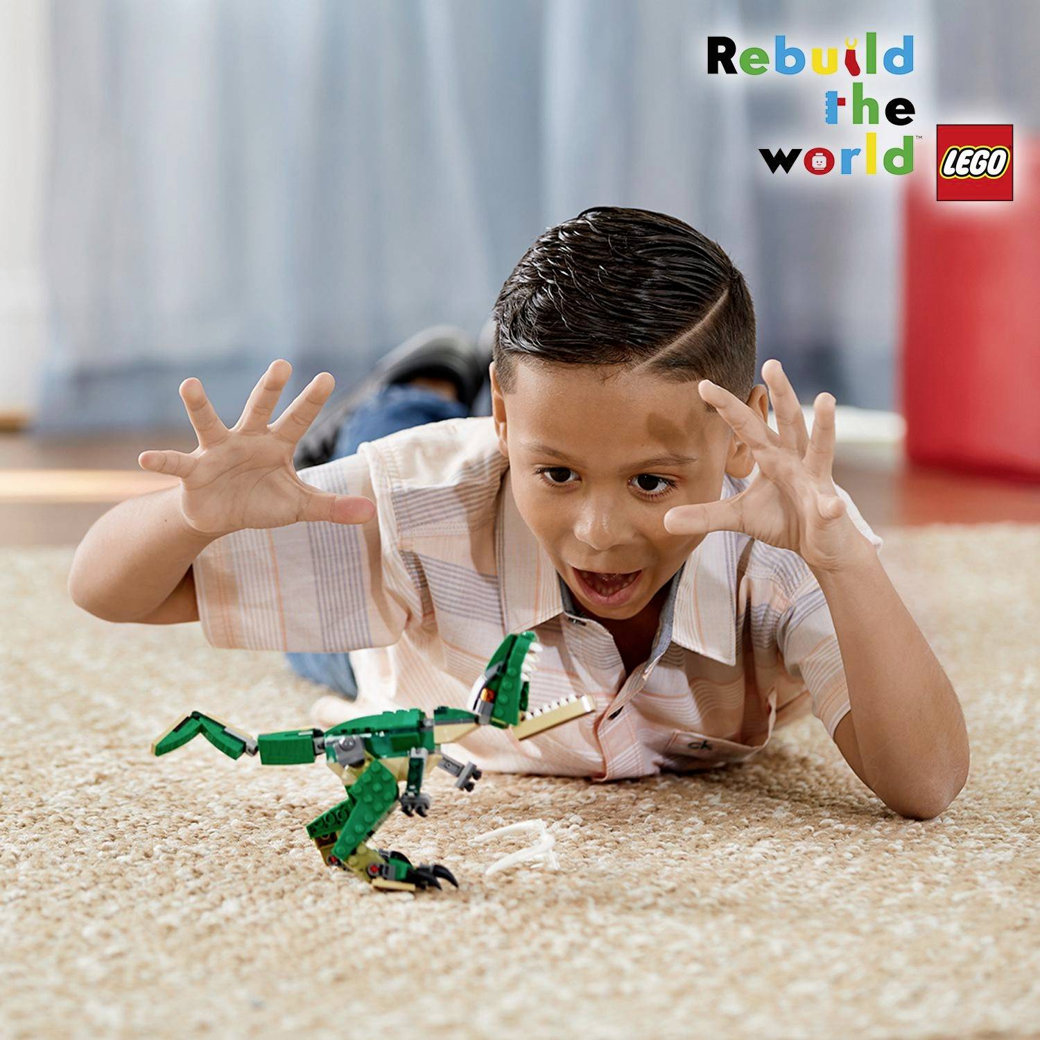 Een jongen speelt enthousiast met een LEGO-robot. Op de achtergrond staat de slogan 'Rebuild the World' met het LEGO-logo.