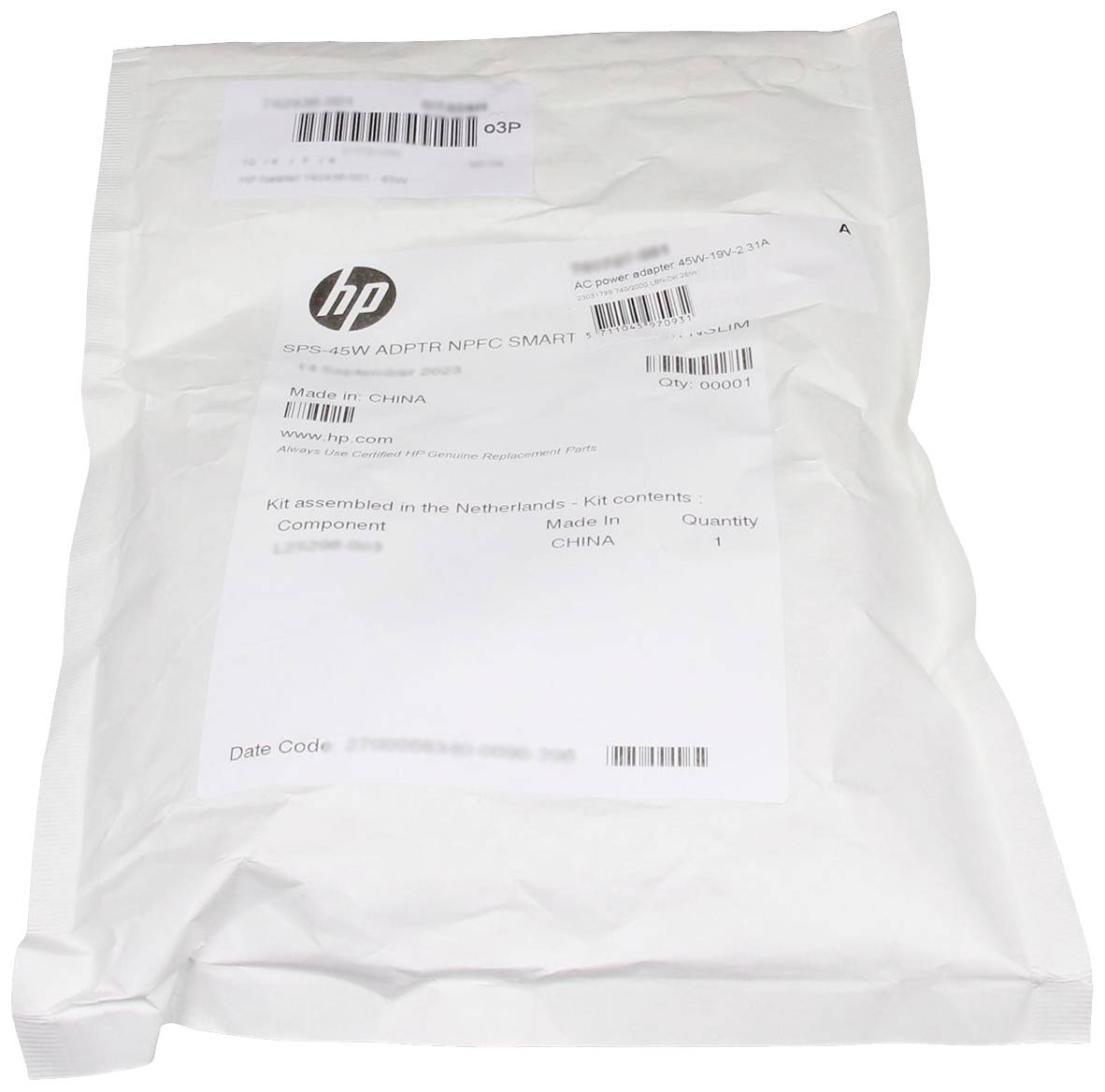Een witte verpakking met een HP-logo, bevat een SPS-45W NFCC Smart adapter. Gemaakt in China, gemonteerd in Nederland.