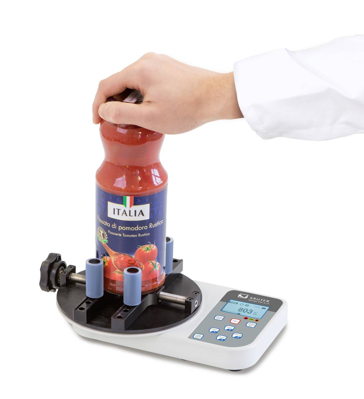 Een persoon test de opening van een pot met een digitale draaimomentenmeter. Het apparaat toont de weerstandswaarde.