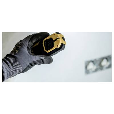 Gehandschoende hand met een gele laserAfstandsmeter gericht op een muur, wat suggereert dat er wordt gemeten of een indeling wordt gemaakt tijdens renovatiewerkzaamheden.