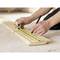 Een persoon meet een houten plank met een meetlint en markeert de positie met een potlood.