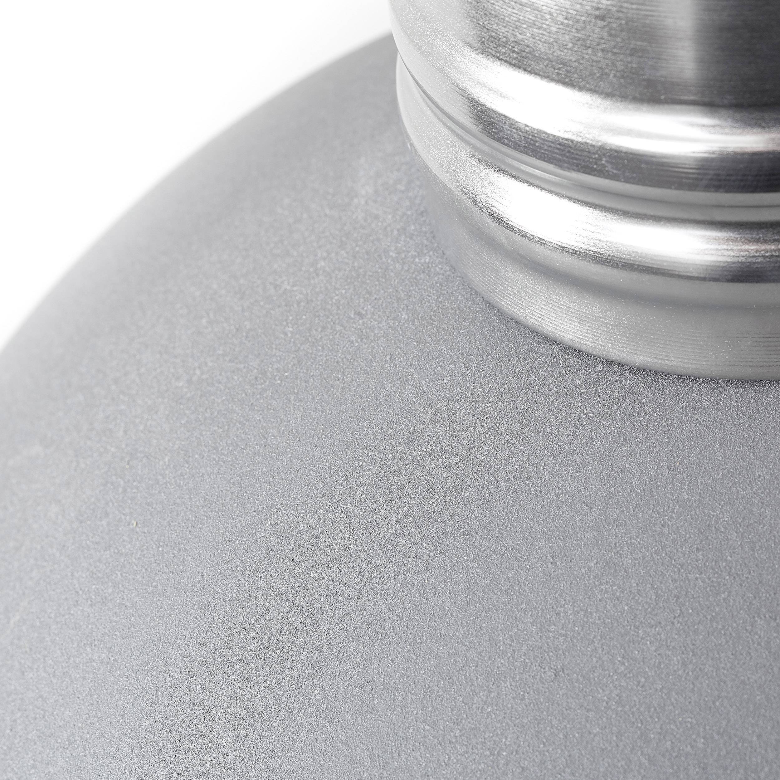 Close-up van een matzilver metalen voorwerp met een glanzende zilveren schroefafsluiting.