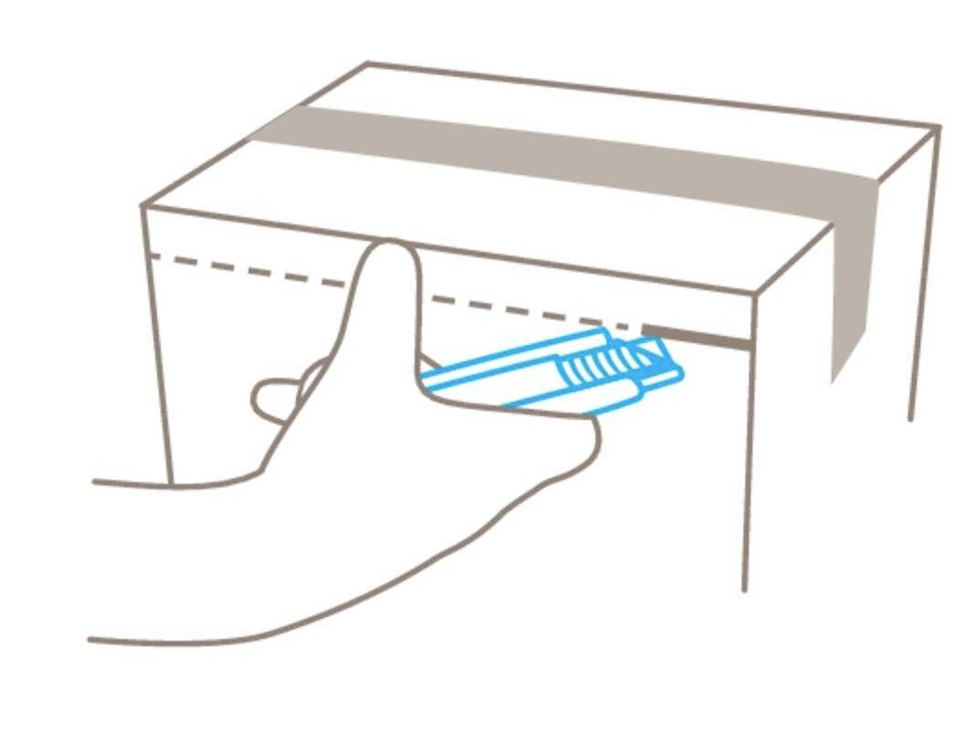 Een hand opent een kartonnen doos met een blauw stanleymes.