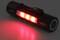 Een zwarte zaklamp schijnt met drie rode LED's in het donker.