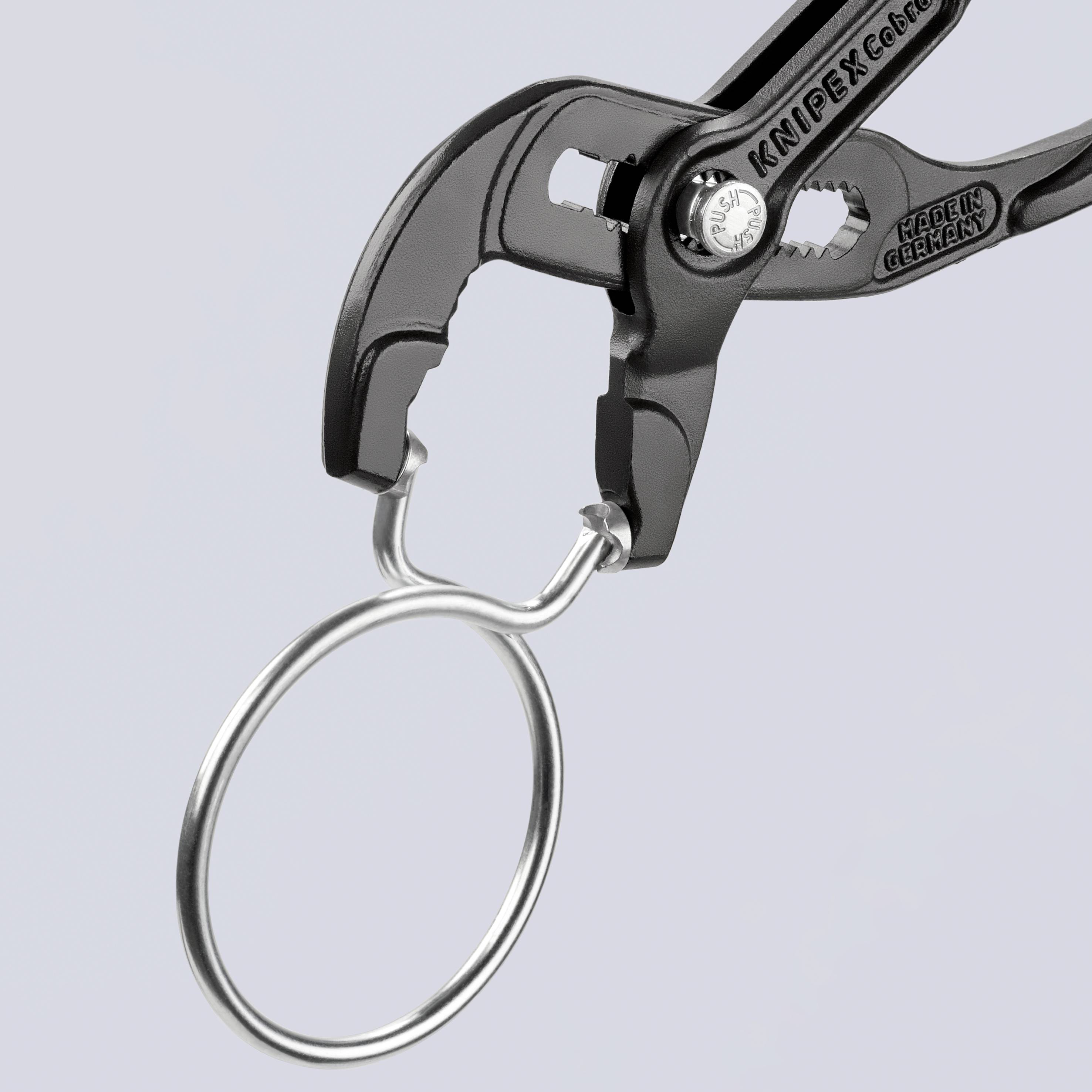 Een kleine, geopende pijpsleutel-sleutelhanger met een metalen oog, die fungeert als miniatuurgereedschap voor decoratie of als sleutelhanger.