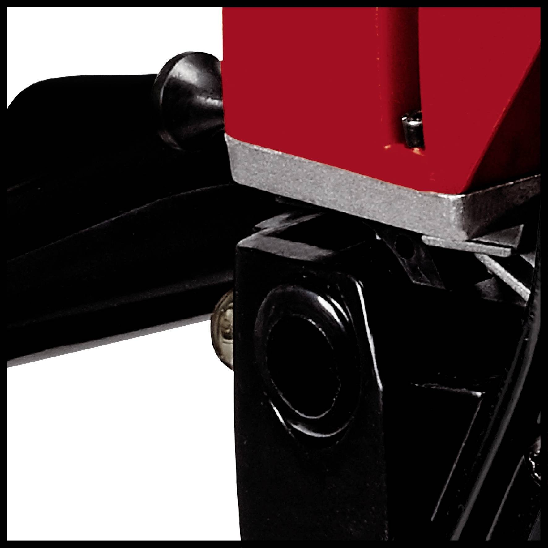 Close-up van een rood en zwart apparaat met zichtbare metalen onderdelen.