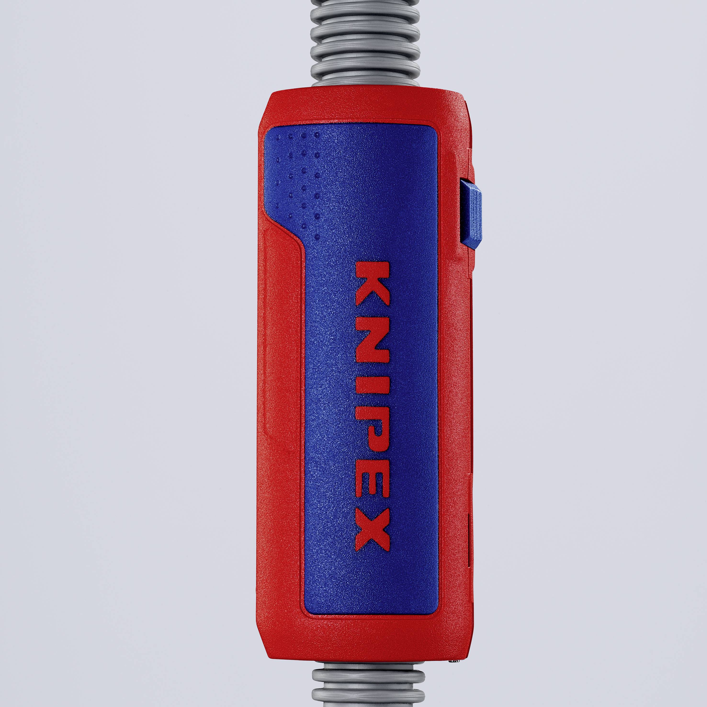 De afbeelding toont een rood-blauwe handgreep van een gereedschap met het opschrift 'KNIPEX' in het midden, grenzend aan een metalen spiraal.