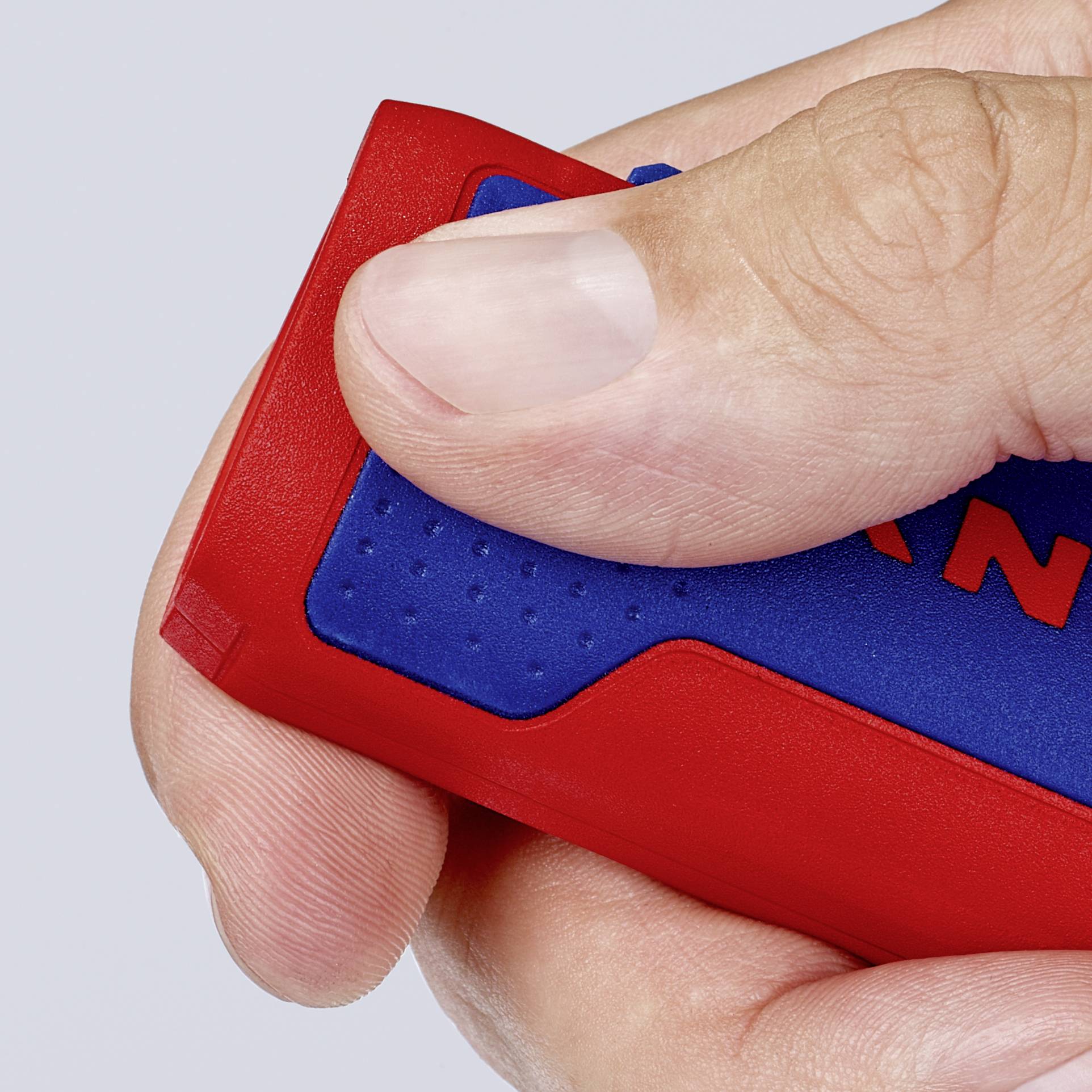 Een hand houdt een blauw-rood voorwerp vast dat eruitziet als een behuizing.