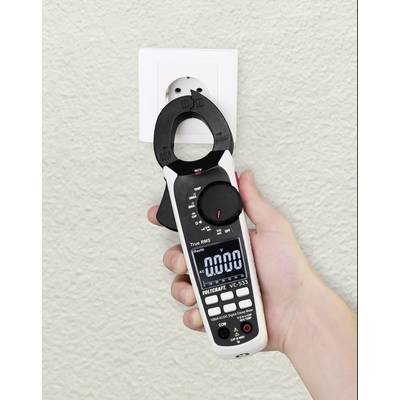 Een hand houdt een multimeter voor een stopcontact, waarbij het display 0,00 aangeeft. Het apparaat wordt mogelijk gecontroleerd op spanning.