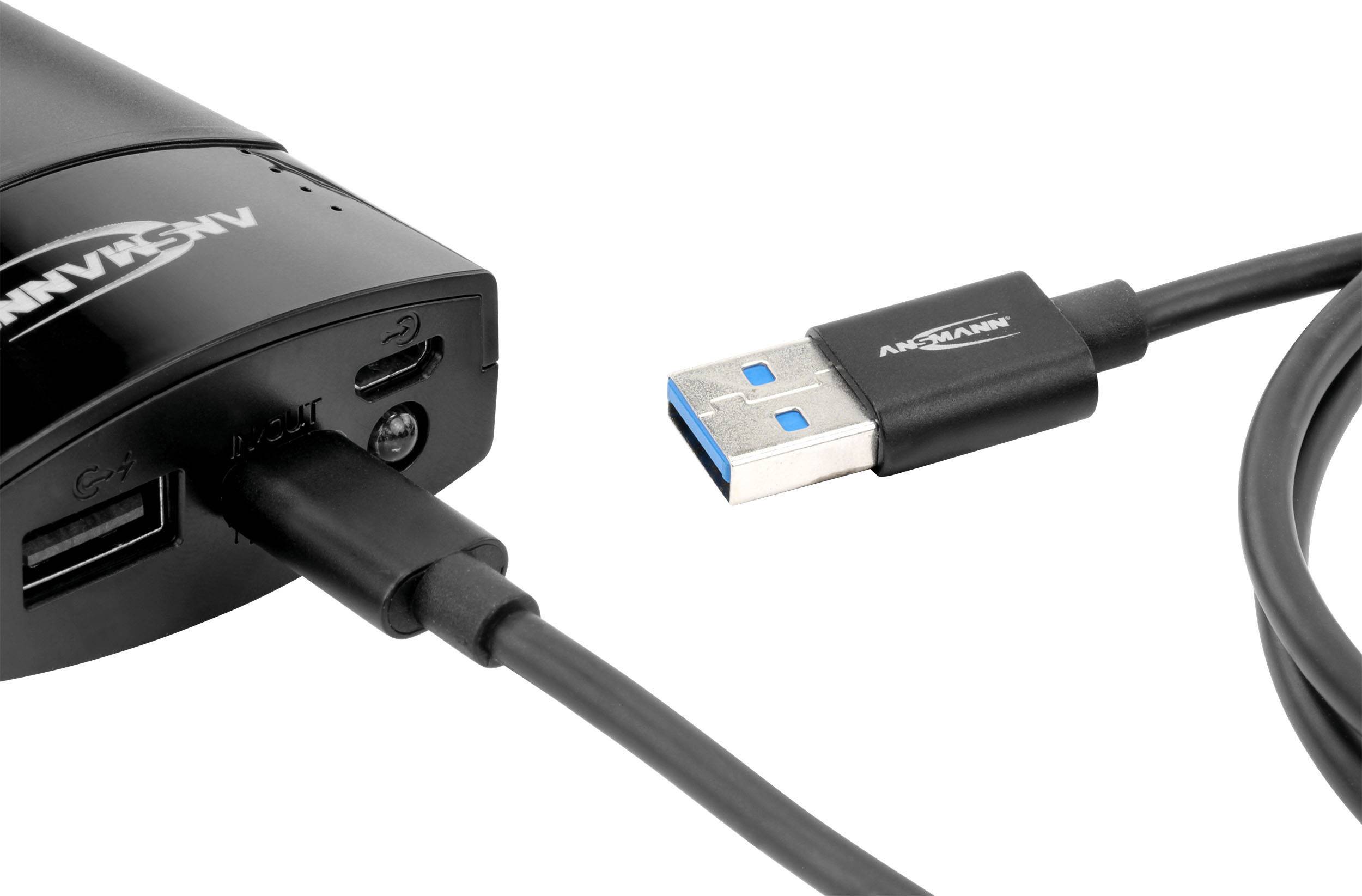 Een zwart apparaat met twee USB-poorten en een Micro-USB-poort, naast een USB-kabel met een blauwe aansluiting.