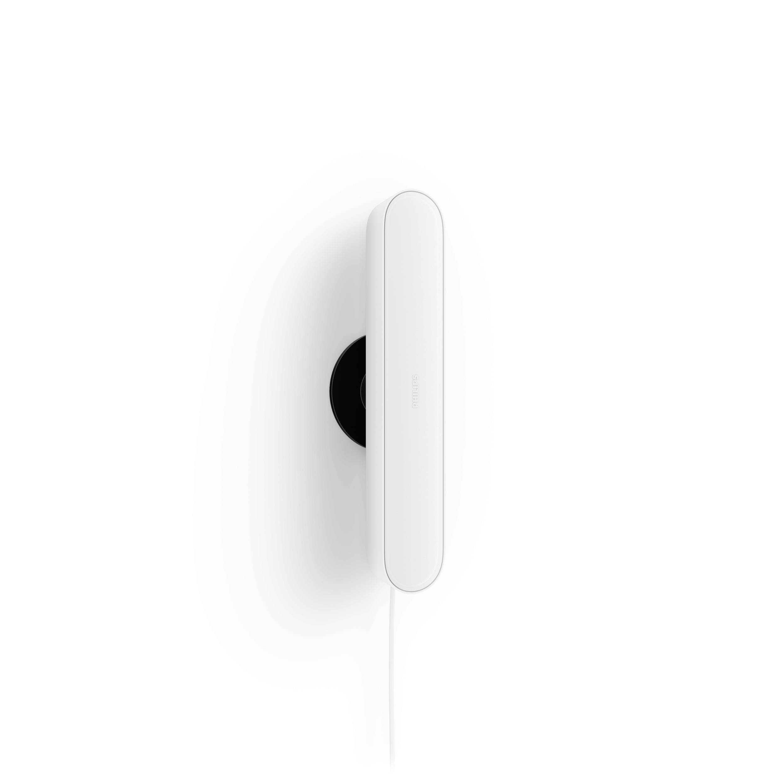 Een wit, ovaal smartphone-oplader gemonteerd aan een witte muur, vertoont een minimalistisch ontwerp met een stroomkabel onderaan.