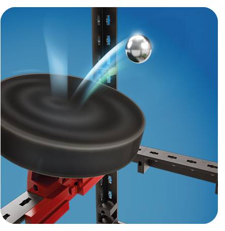 Een metalen bal vliegt naar een zwarte deksel toe, bevestigd op een rood-zwarte mechaniek, tegen een blauwe achtergrond.