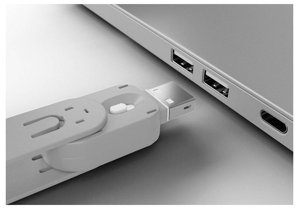 Close-up van een USB-stick die in een USB-poort van een laptop wordt ingestoken naast een ander poort en een koptelefoonaansluiting.