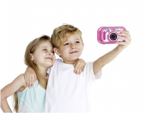 Twee lachende kinderen maken een selfie met een roze camera, het meisje omarmt de jongen, beiden zijn vrolijk.