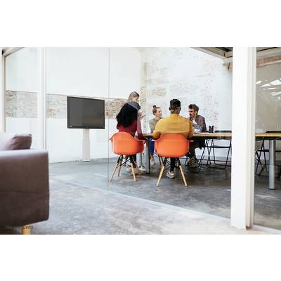 Verschillende personen zitten aan een tafel in een lichte, moderne vergaderruimte. Ze discussiëren en werken samen aan een project.