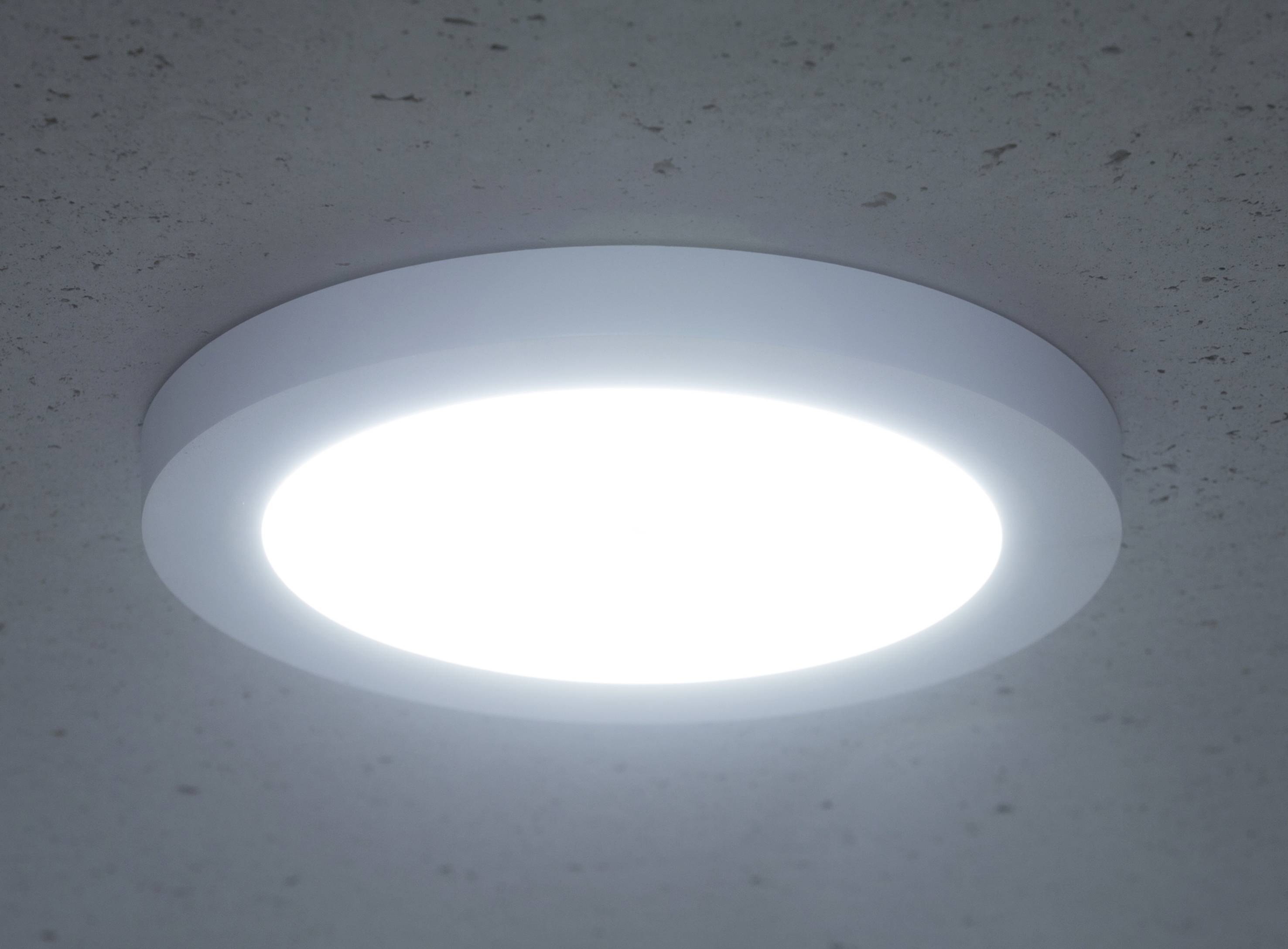 Ronde plafondlamp straalt helder, wit licht uit dat gelijkmatig wordt verspreid over het omringende oppervlak.