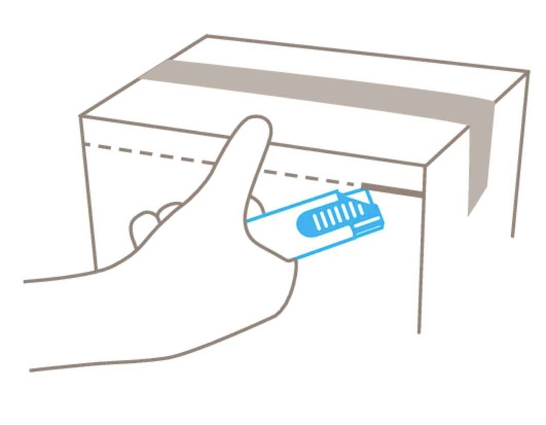 Een hand steekt een blauwe teststrip in een kartonnen doos met een gleuf.