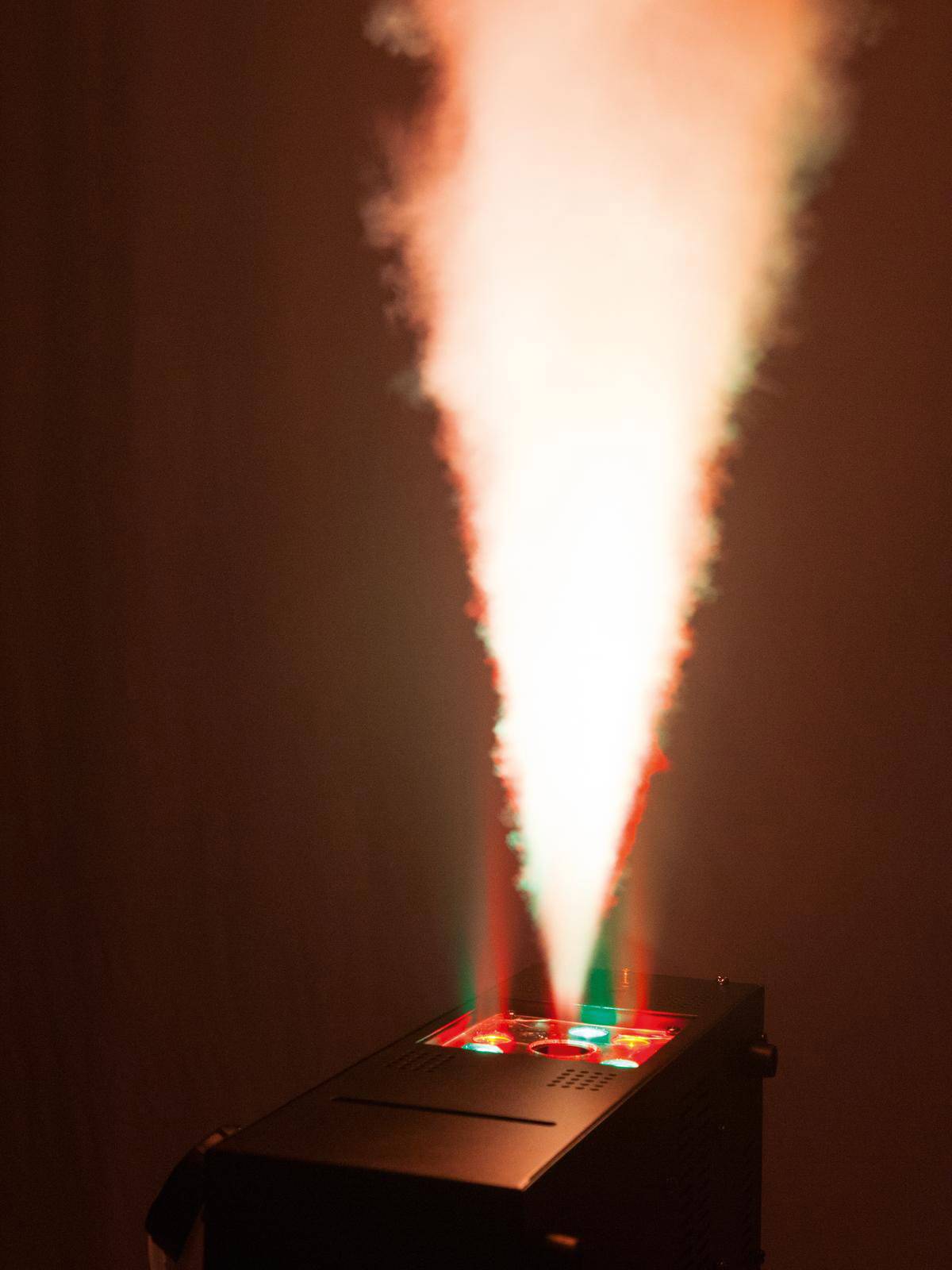 Lasereffectapparaat met rookmachine dat rode en groene stralen produceert, die een atmosferische lichtstraal in de ruimte projecteren.