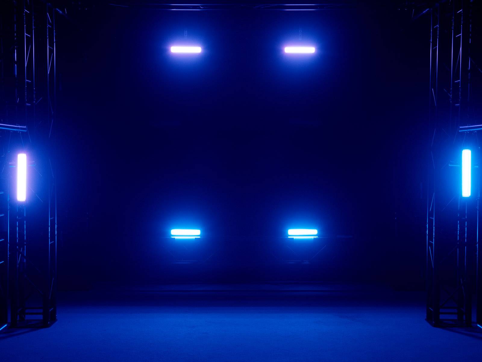 Podium met blauwe schijnwerpers die in een donkere ruimte schijnen.