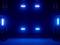 Podium met blauwe schijnwerpers die in een donkere ruimte schijnen.