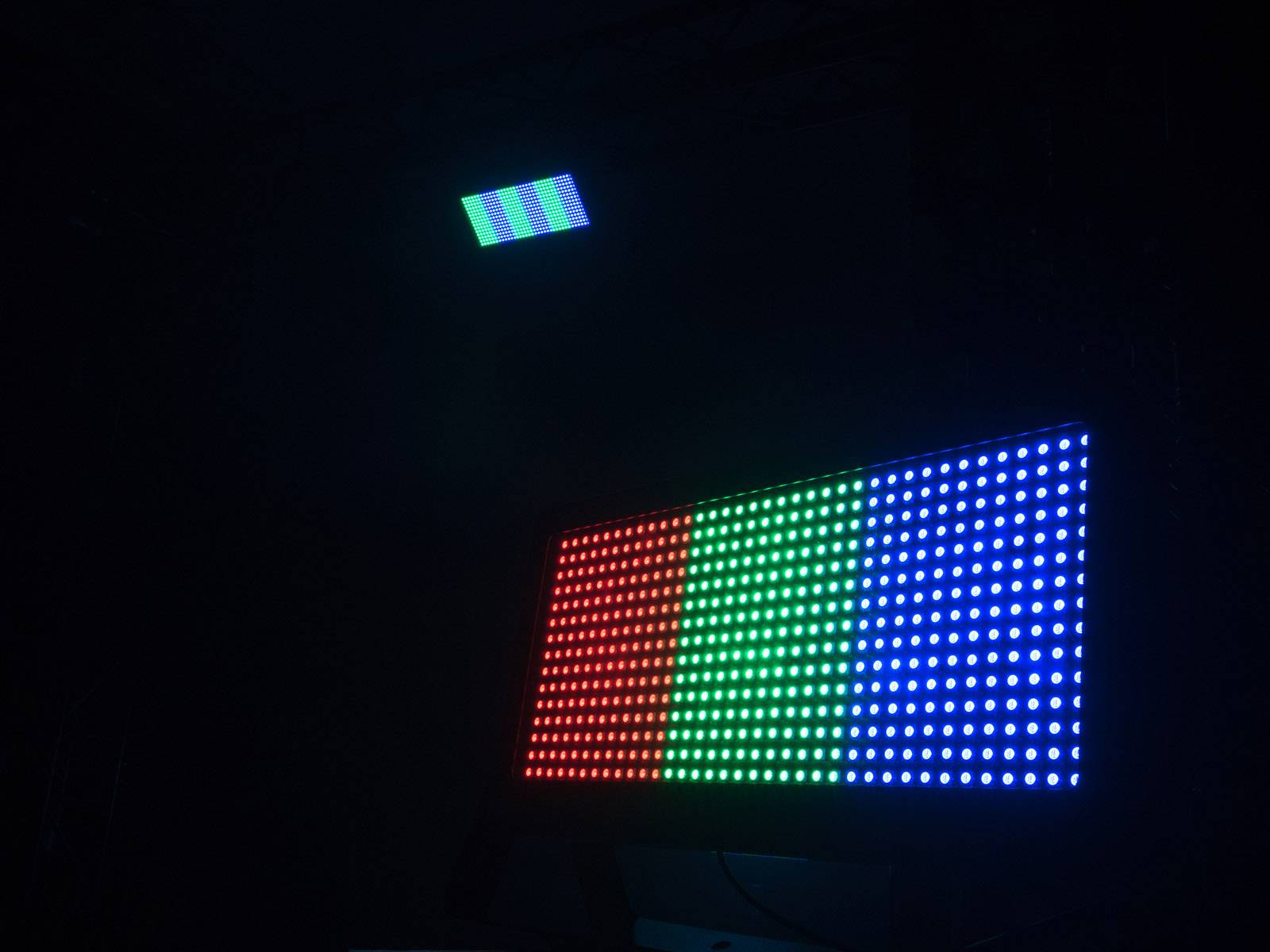 Een groot led-display toont verticale balken in rood, groen en blauw. Boven staat een kleiner, vergelijkbaar display met dezelfde kleuren.