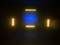 Podium met gekleurde verlichting; blauw licht op de achtergrond, omgeven door warmwitte schijnwerpers, creëert een dramatische sfeer.